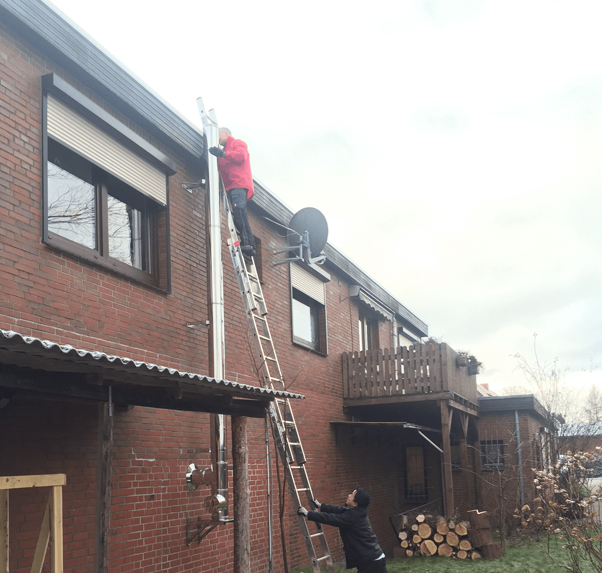 Montage eines Edelstahlschornsteins an der Hauswand